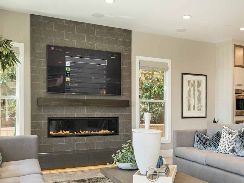 in-ceiling lights in a lounge space with a large tv above a fireplace