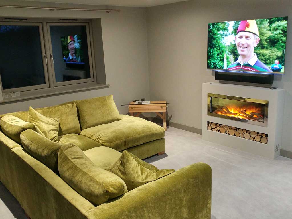 Smart TV above a fireplace with in-ceiling speakers
