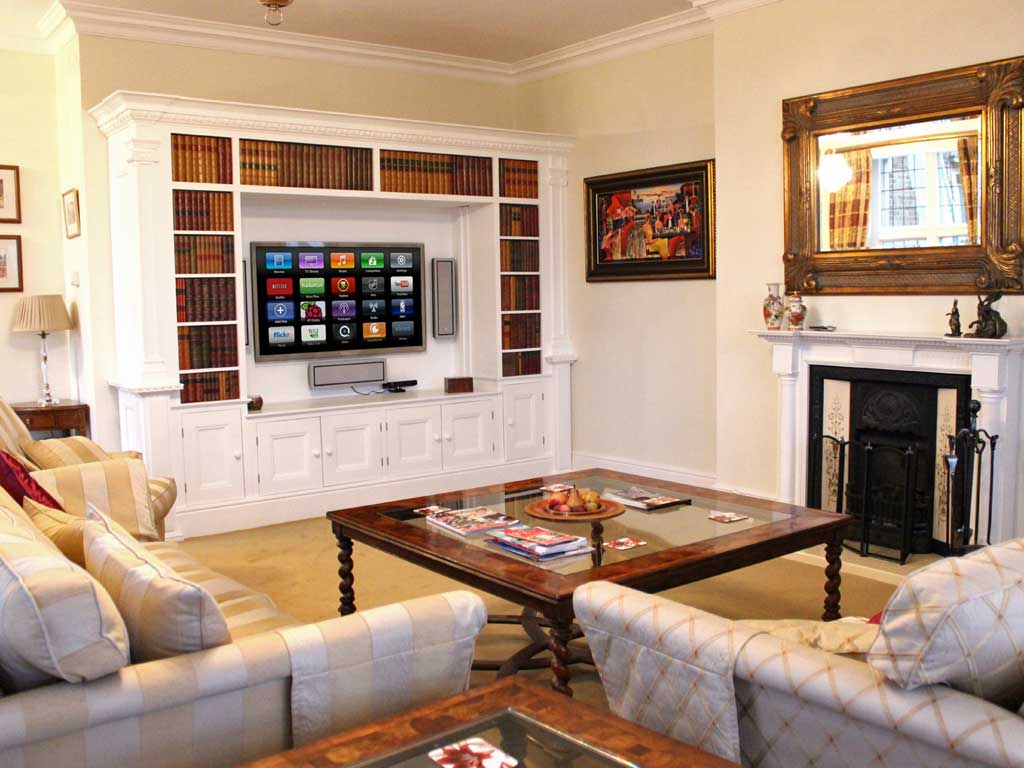 TV mounted in the wall above a fireplace