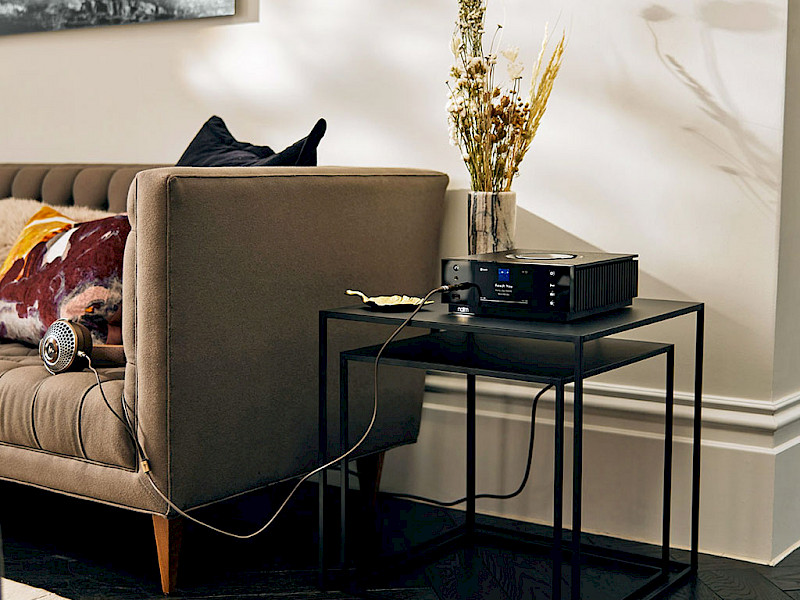 Uniti Atom Headphone on table next to brown sofa
