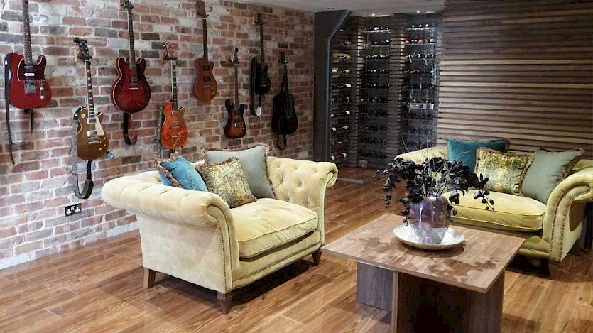 Cinema Room, guitars on the wall with two white leather sofas